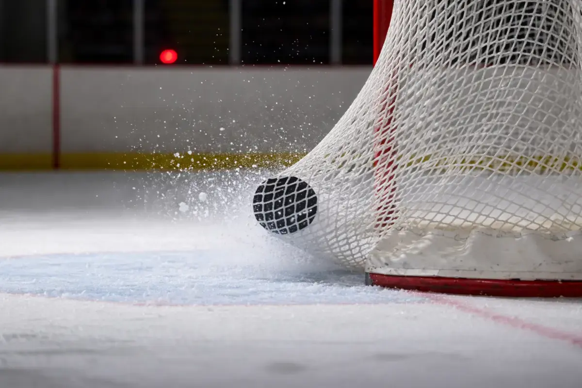Puck im Eishockeytor-Netz – Symbolbild für Over/Under-Torwetten im Eishockey